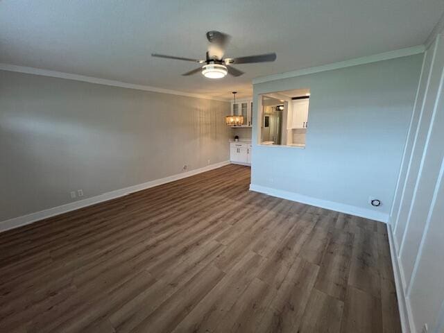 spare room with ceiling fan with notable chandelier, ornamental molding, and dark hardwood / wood-style flooring