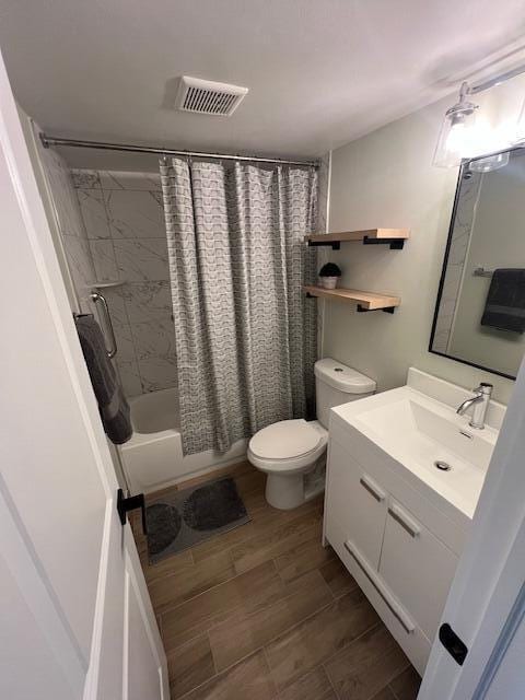 full bathroom featuring vanity, toilet, shower / bathtub combination with curtain, and hardwood / wood-style flooring