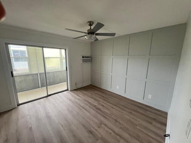 spare room featuring crown molding, ceiling fan, a wall mounted air conditioner, and light hardwood / wood-style flooring