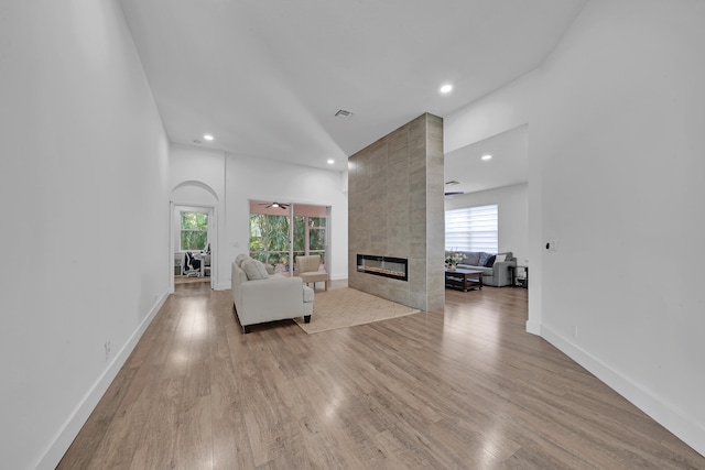 unfurnished living room featuring a fireplace, light hardwood / wood-style flooring, and ceiling fan