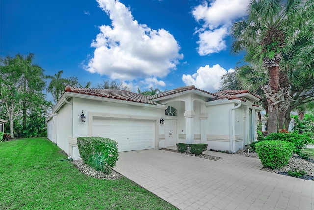 mediterranean / spanish-style home with a garage and a front lawn