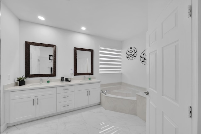 bathroom with vanity and tiled tub