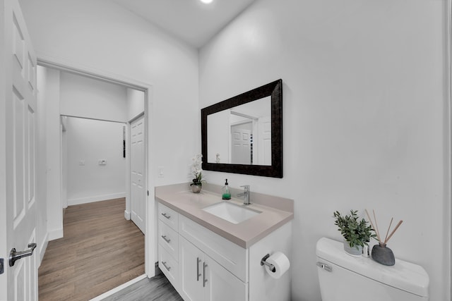 bathroom with vanity, toilet, and wood-type flooring