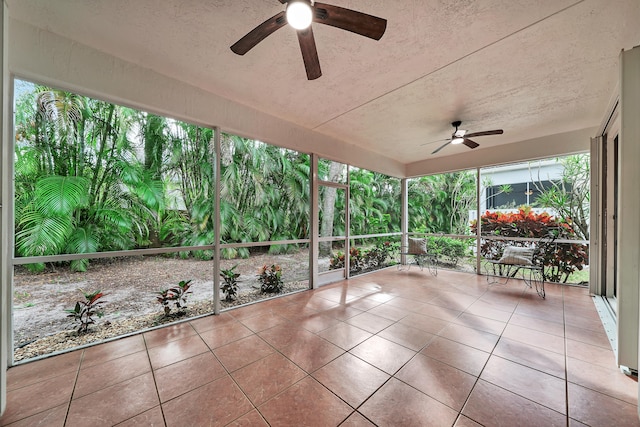 unfurnished sunroom featuring ceiling fan