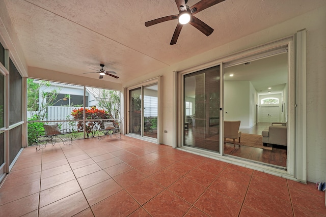 unfurnished sunroom featuring ceiling fan