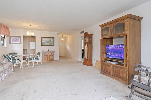 carpeted living room featuring an inviting chandelier