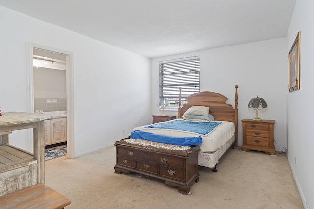 bedroom with ensuite bath and light carpet