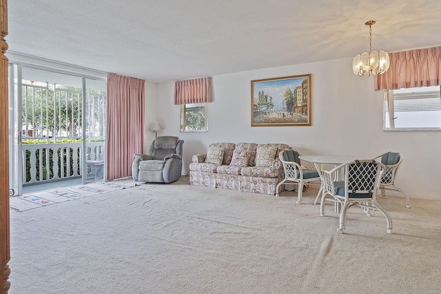 living room featuring an inviting chandelier, plenty of natural light, and carpet flooring