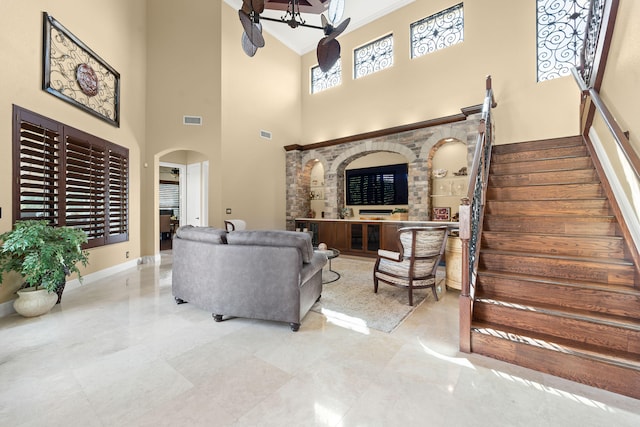 living room featuring a towering ceiling and ceiling fan