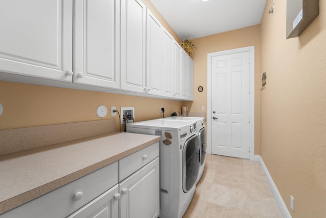 clothes washing area featuring cabinets and washing machine and clothes dryer