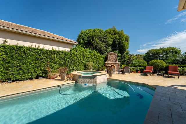 view of swimming pool featuring an in ground hot tub, a patio area, and an outdoor stone fireplace