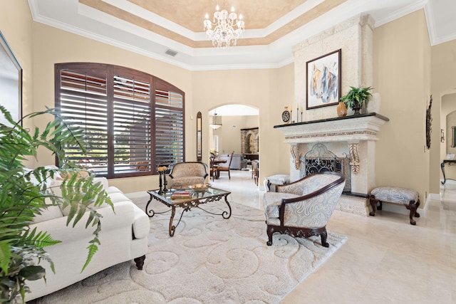 living room with ornamental molding, a notable chandelier, and a raised ceiling