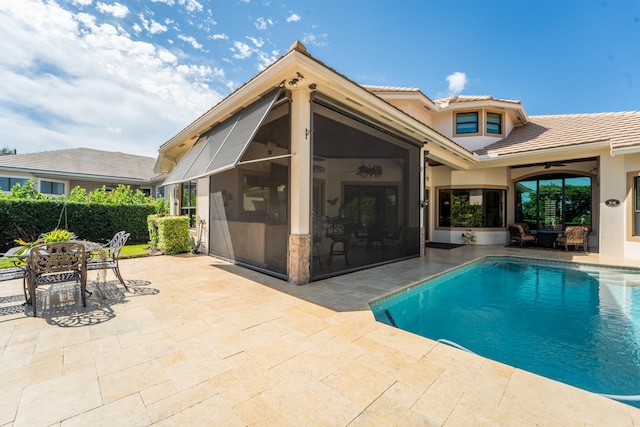 view of pool with a patio area, a sunroom, and ceiling fan