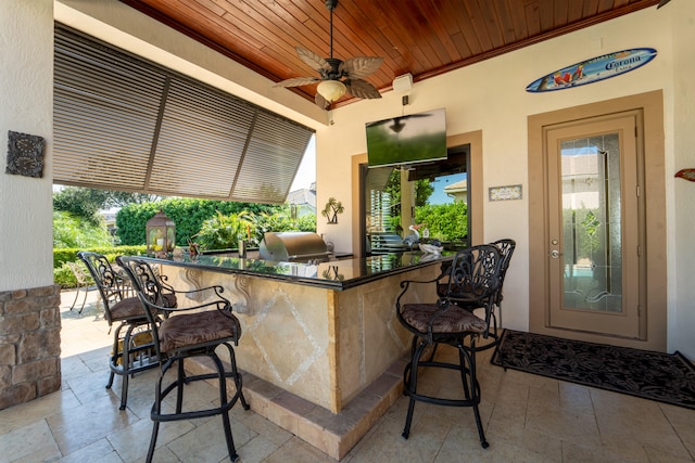 view of patio featuring an outdoor bar, exterior kitchen, area for grilling, and ceiling fan