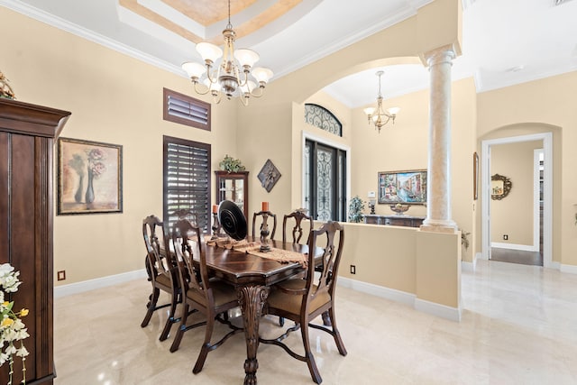 dining room with a notable chandelier, crown molding, ornate columns, and a tray ceiling