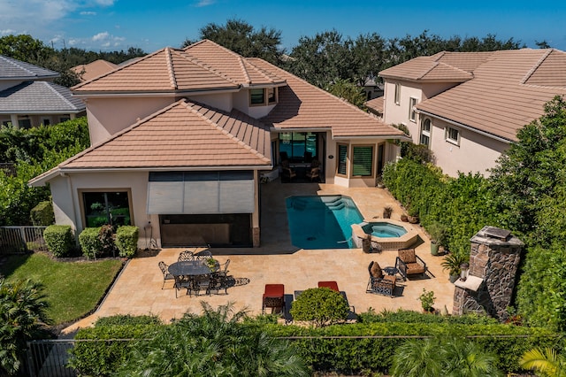 back of house featuring a patio area and an in ground hot tub