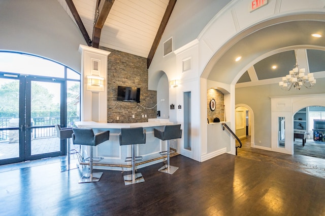 kitchen featuring a healthy amount of sunlight, high vaulted ceiling, dark wood-type flooring, and a breakfast bar