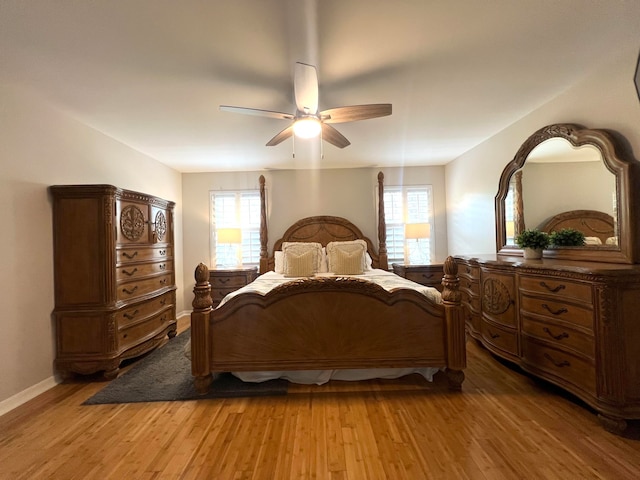 bedroom featuring ceiling fan, wood-type flooring, and multiple windows