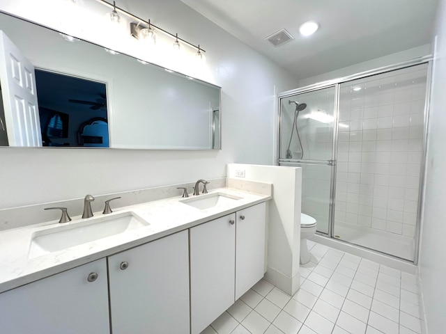 bathroom featuring toilet, a shower with shower door, vanity, and tile patterned flooring