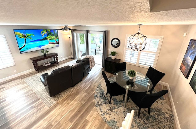 dining space featuring hardwood / wood-style floors, a textured ceiling, and a healthy amount of sunlight