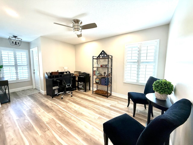 home office with light hardwood / wood-style floors and ceiling fan