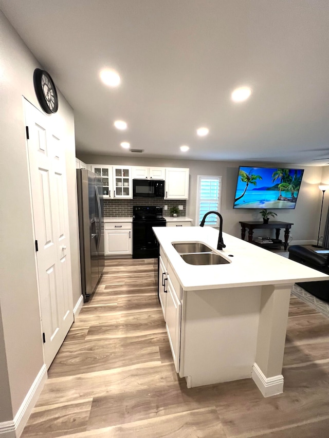 kitchen with light hardwood / wood-style flooring, black appliances, sink, and white cabinets