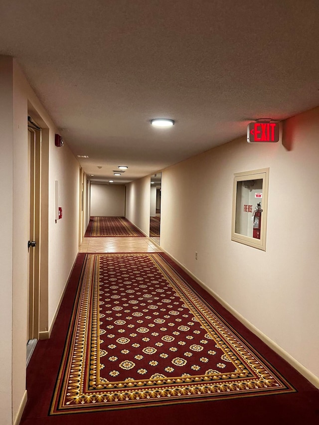 hall featuring dark colored carpet