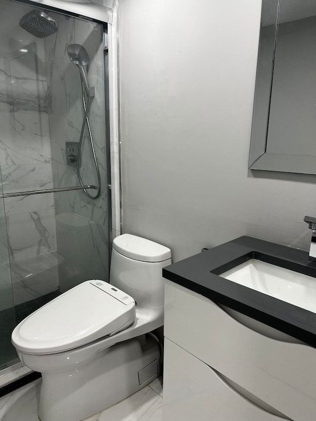 bathroom featuring a shower with door, vanity, and toilet