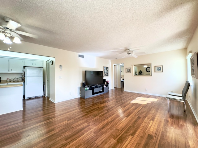 unfurnished living room featuring a textured ceiling, dark wood-type flooring, and ceiling fan