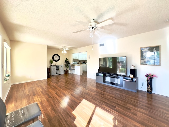 living room featuring a textured ceiling, dark hardwood / wood-style floors, and ceiling fan