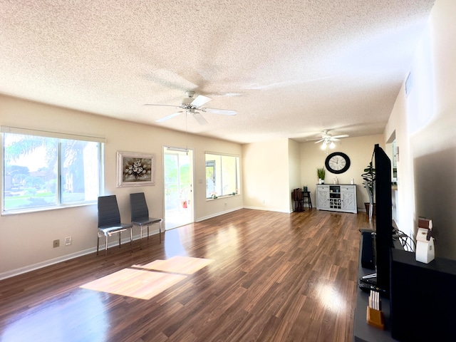 living room with ceiling fan, dark wood-type flooring, and a textured ceiling