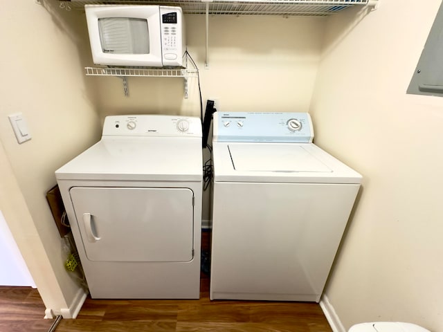 laundry room featuring electric panel, dark wood-type flooring, and washing machine and dryer