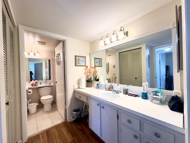 bathroom with hardwood / wood-style floors, vanity, and toilet