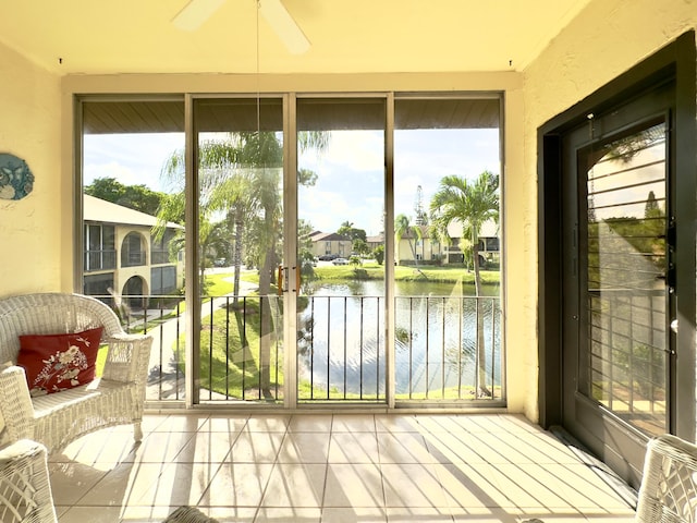 sunroom / solarium with ceiling fan, plenty of natural light, and a water view