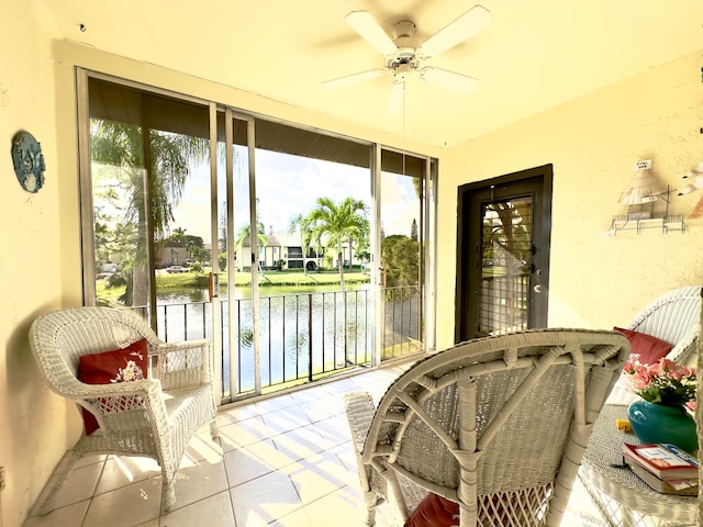 sunroom / solarium with a water view and ceiling fan