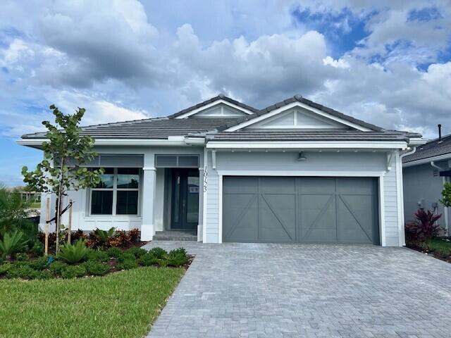 10125 Driftwood Way, Palm Beach Gardens, FL 33412 - ranch-style home with decorative driveway and an attached garage