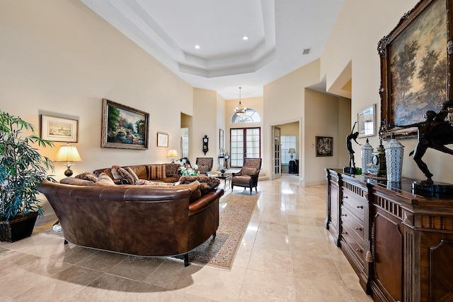 living room featuring a raised ceiling and a high ceiling