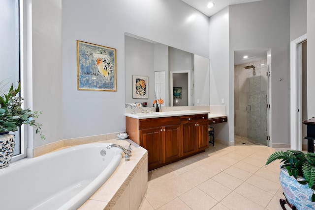 bathroom with tile patterned flooring, independent shower and bath, and vanity