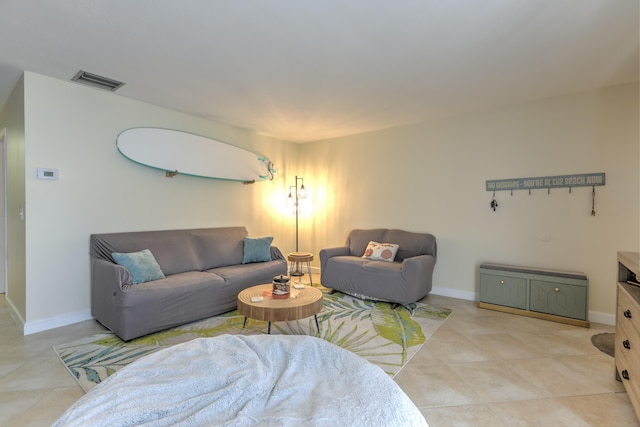 living room featuring baseboards, visible vents, and light tile patterned floors
