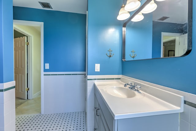bathroom featuring tile patterned floors, visible vents, tile walls, and vanity