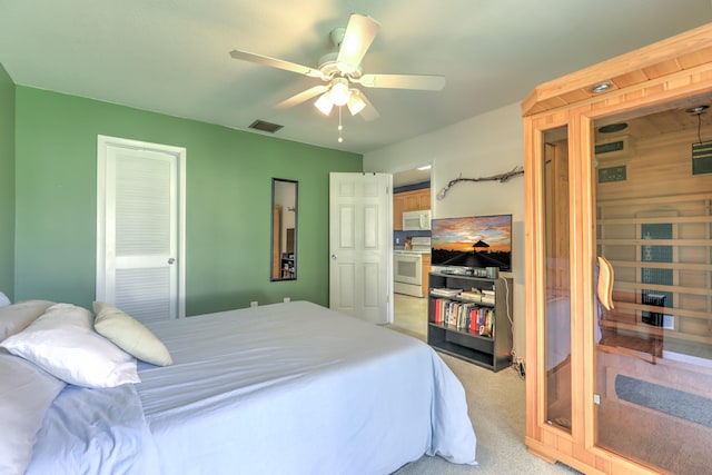 bedroom featuring a ceiling fan, visible vents, and light carpet