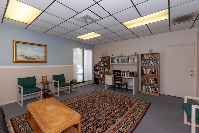 sitting room featuring carpet, visible vents, and a drop ceiling