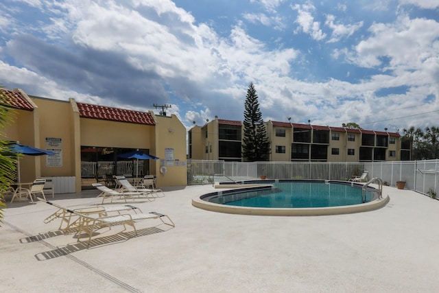 pool featuring fence and a patio area