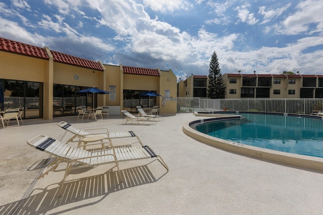 pool with a patio and fence
