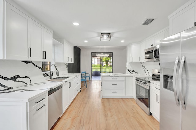 kitchen with stainless steel appliances, white cabinetry, and sink