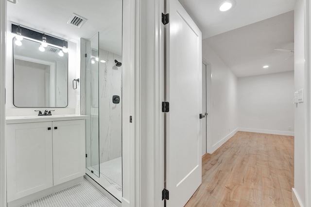 bathroom with walk in shower, hardwood / wood-style floors, and vanity