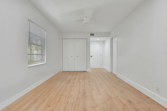 unfurnished bedroom with light hardwood / wood-style floors, ceiling fan, and a closet