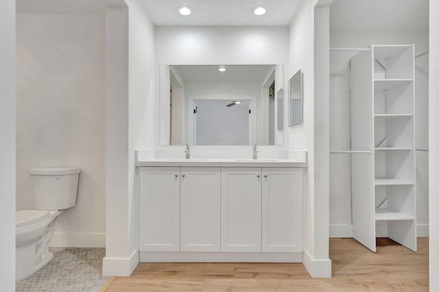 bathroom with hardwood / wood-style floors, vanity, and toilet