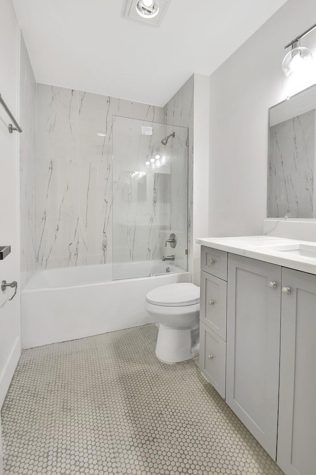 full bathroom featuring tile patterned flooring, tiled shower / bath, toilet, and vanity