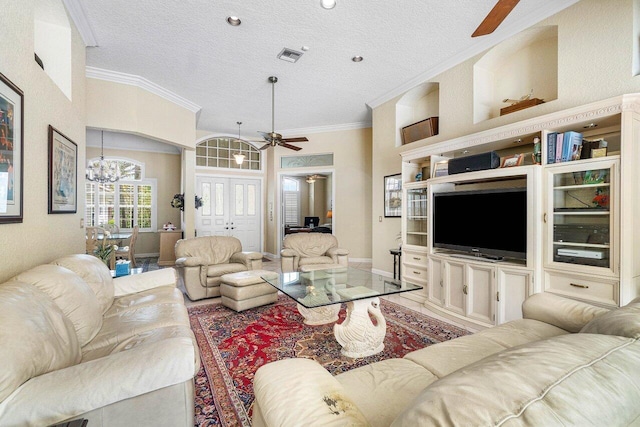 living room featuring a textured ceiling, ceiling fan with notable chandelier, a high ceiling, and ornamental molding